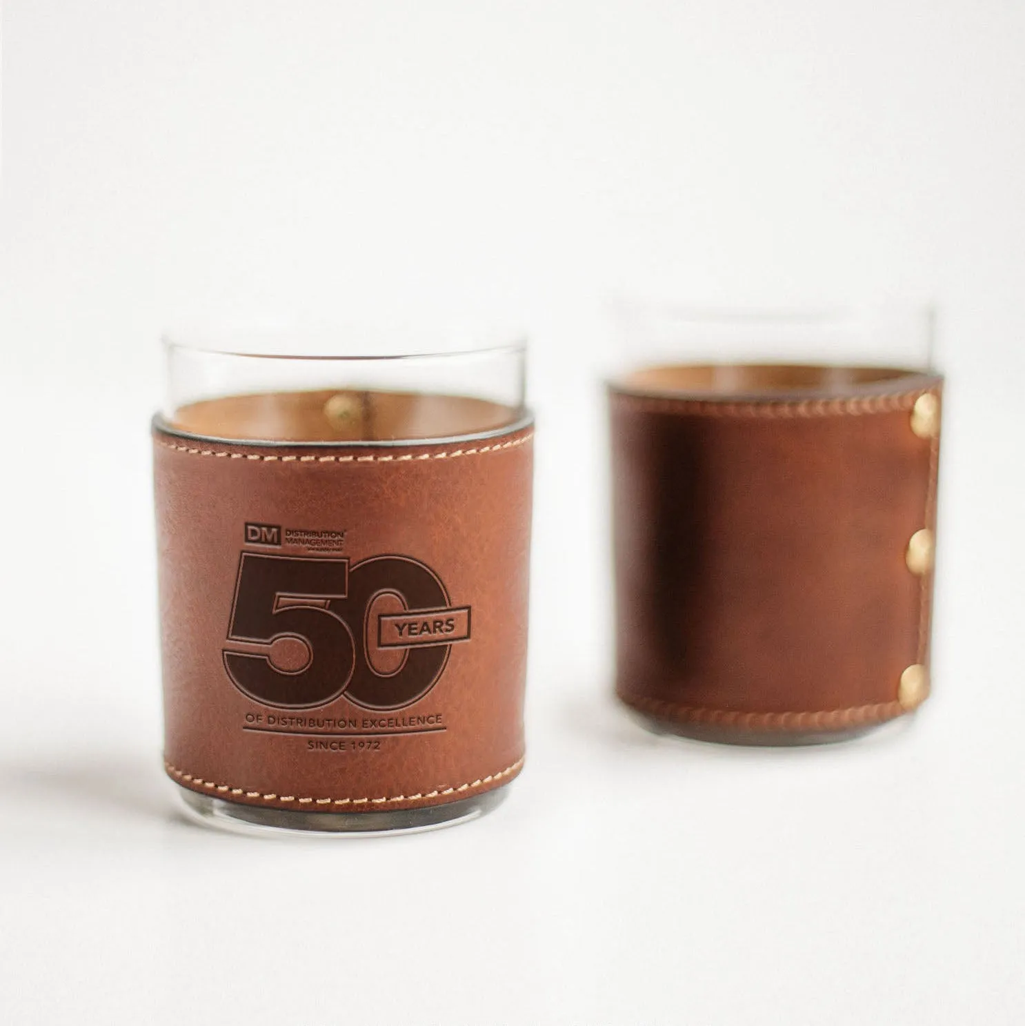 Pair of rocks glasses wrapped in laser-engraved leather sleeves