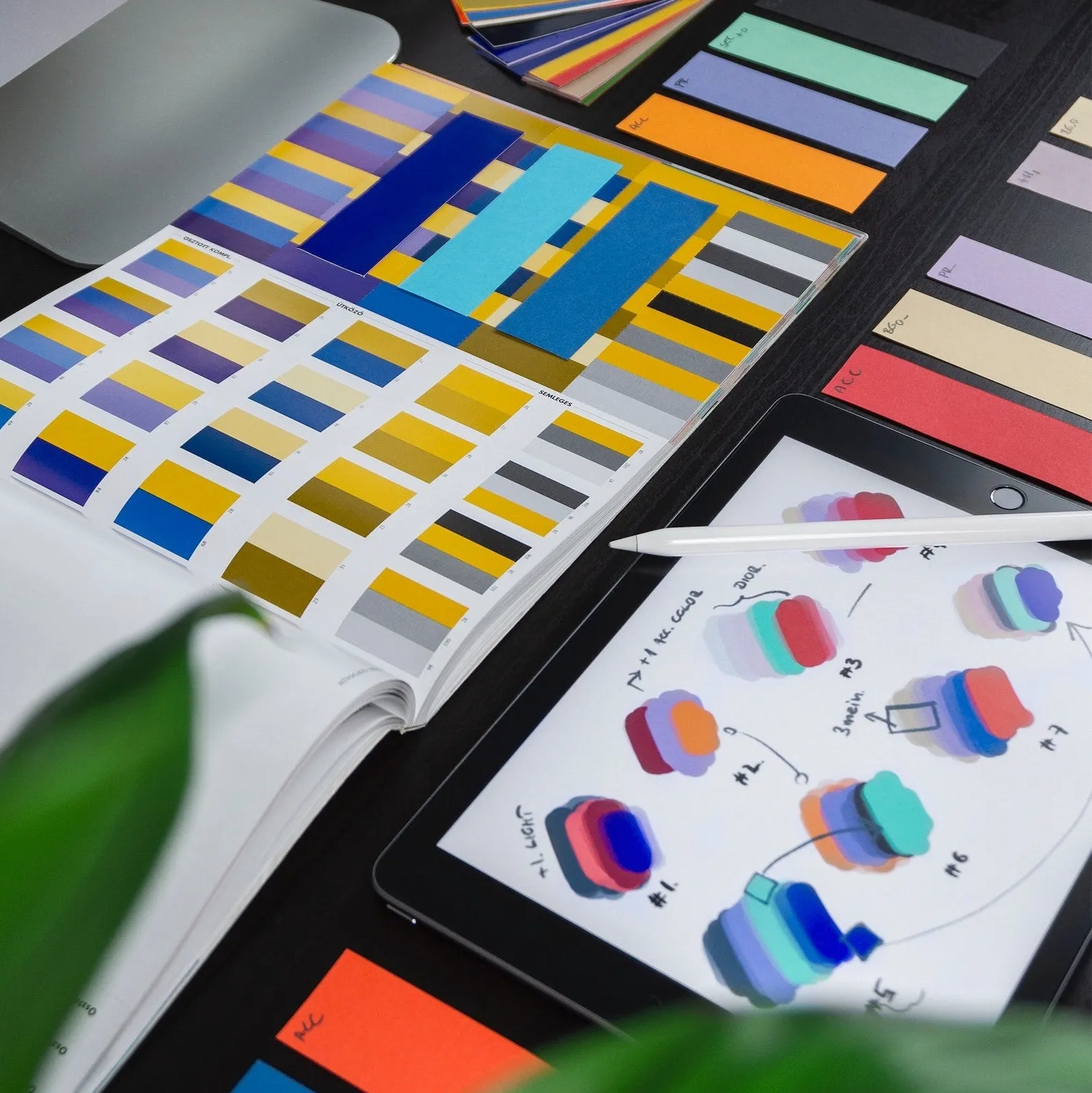 Color swatch books and palette samples spread across a design table
